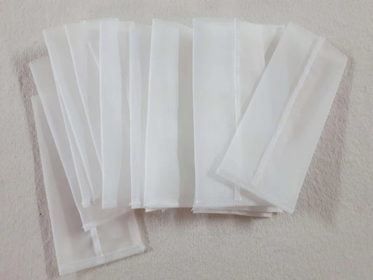 A collection of white rectangular mesh bags for rosin pressing.