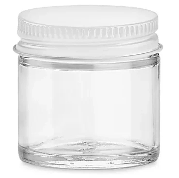 Small clear glass cosmetic jar with a white screw-on lid